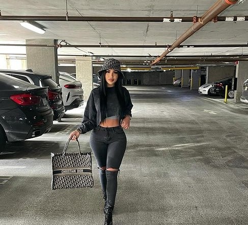 Karina Seabrook posing for her Instagram feed by wearing black pant and crop Tee.